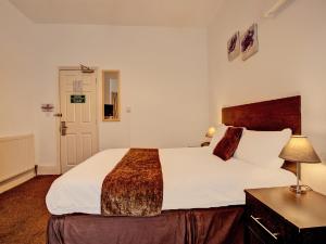 a hotel room with a large bed and a desk at The Waverley Hotel in Great Yarmouth