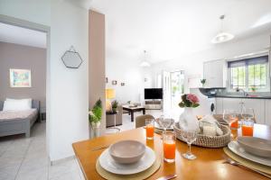 a dining room and living room with a table with wine glasses at Aptera Beach Apartment in Kato Daratso