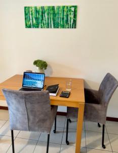 a wooden table with a laptop computer on top of it at Lake Como View Apartement Allegro in Acquaseria