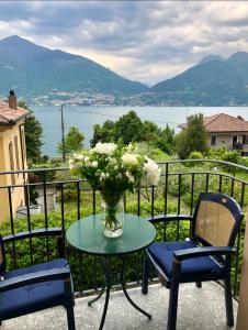 una mesa con un jarrón de flores en el balcón en Lake Como View Apartement Allegro, en Acquaseria