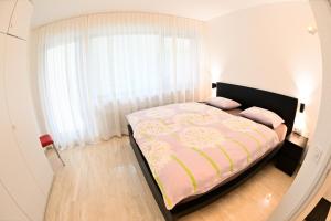 Schlafzimmer mit einem Bett und einem großen Fenster in der Unterkunft Casa Milo al lago in Locarno