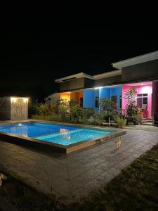 - une piscine en face d'une maison la nuit dans l'établissement Kedawang Village Langkawi, à Pantai Cenang