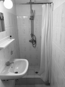 baño blanco con ducha y lavamanos en Stone House Limnos en Repanídhion