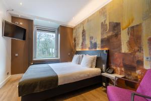 a hotel room with a bed and a tv at Amrâth Berghotel Amersfoort, BW Signature Collection in Amersfoort