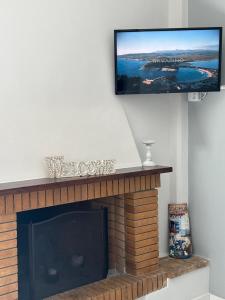 a living room with a fireplace with a flat screen tv on the wall at Navarino Golden sunset Apartment in Pylos