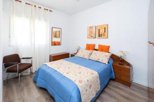 a bedroom with a blue bed and a chair at Cortijo Ginatar in Dúrcal