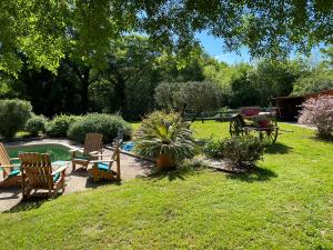 einen Garten mit Stühlen und einem Pool im Gras in der Unterkunft Chambre d hôte petit crussac in Mauvezin