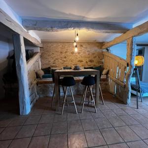 a dining room with a table and two stools at Chambre d hôte petit crussac in Mauvezin