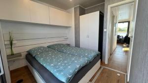 Hausboot Joana في تسيهدينك: غرفة نوم صغيرة مع سرير وخزانة