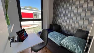 a room with a desk and a bed with a laptop at Hausboot Joana in Zehdenick