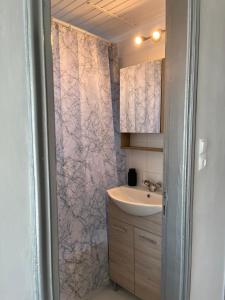 a bathroom with a sink and a shower curtain at Golden Navarino's Sunset in Pylos +40 photos