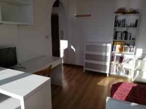 a kitchen with a table and a book shelf at La casa di Rina in Ponzone