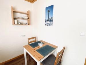 mesa de comedor con 2 sillas y una foto en la pared en FEWO Vanessa, en Willingen