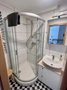 a bathroom with a shower and a sink at Apartamentai KOPOS Nidoje in Nida