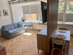 Apartamentai KOPOS Nidoje في نيدا: غرفة معيشة مع أريكة وطاولة
