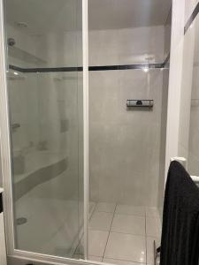 La salle de bains est pourvue d'une douche avec une porte en verre. dans l'établissement Un cocon au cœur de la champagne avec parking, à Épernay