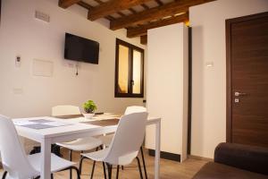 a dining room with a white table and white chairs at casa vacanza zu ciano in Marausa