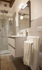 a bathroom with a sink and a shower and towels at casa vacanza zu ciano in Marausa