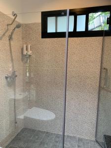 a bathroom with a shower and a tub and a toilet at Noble House Beach Resort in Ko Lanta