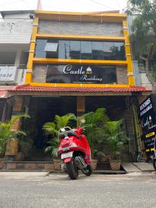 a red scooter parked in front of a restaurant at Castle 360 Residency in Pondicherry