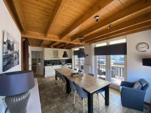 a kitchen and dining room with a wooden table and chairs at Unique Holiday Home with Terrace Barbecue Garden Furniture in Delfstrahuizen