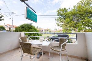 eine Terrasse mit einem Tisch und Stühlen auf dem Balkon in der Unterkunft Alexandra Studios in Kallithea (Chalkidiki)