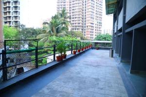 a walkway in a building with palm trees and buildings at Country Inn By Turtle Hotel and Resort- Mumbai International Airport in Mumbai