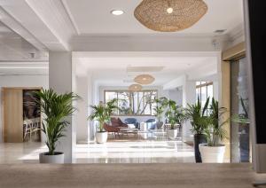 a hallway with potted plants in a building at Hotel Ankaa - Adults Only in Porto Cristo