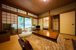 una sala de estar con una mesa de madera en una habitación en Auberge Funoki, en Nakatsu
