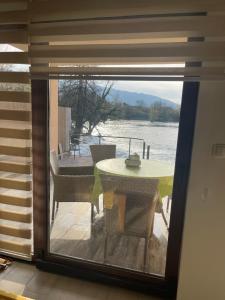 a patio with a table and a view of the water at Apartment Vila Tara in Bihać