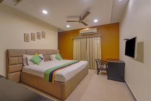 - une chambre avec un lit et une télévision à écran plat dans l'établissement Treebo Trend Elan, à Chennai