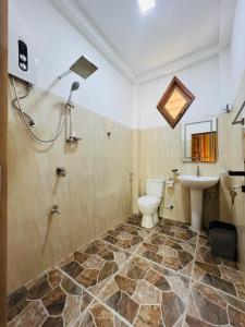 a bathroom with a toilet and a sink at Turtle Wood Cabin in Tangalle