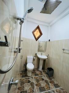 a bathroom with a shower and a toilet and a sink at Turtle Wood Cabin in Tangalle