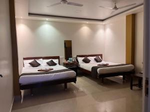 a hotel room with two beds in a room at Castle 360 Residency in Pondicherry