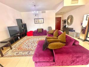 a living room with a pink couch and a tv at Amazing and spacious apartment in JBR in Dubai