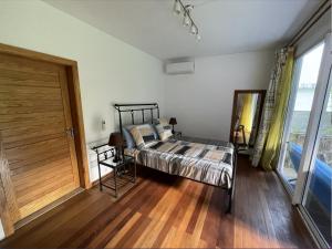 a bedroom with a bed and a wooden floor at 2 bedroom Apartment -Villa Ibiza in Trou dʼ Eau Douce