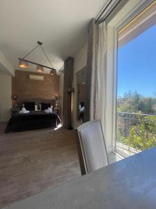 a bedroom with a bed and a large window at Hôtel de La Fossette in Le Lavandou