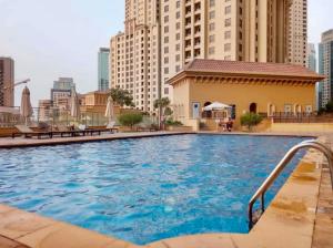 a large swimming pool in a city with tall buildings at Amazing and spacious apartment in JBR in Dubai