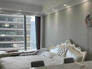 a bedroom with a white bed and a large window at SuzhouGoethe Apartment in Suzhou