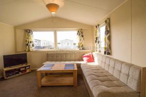 a living room with a couch and a table at Superb 6 Berth, Dog Friendly Caravan For Hire By The Beach In Norfolk Ref 50008m in Great Yarmouth