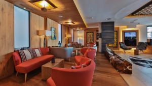 a lobby with red chairs and a living room at Hotel Fliana Ischgl in Ischgl