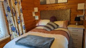 a bedroom with a bed in a log cabin at Snowdonia Log cabin in Trawsfynydd