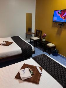 a hotel room with two beds and a flat screen tv at Castle 360 Residency in Pondicherry