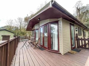 a large wooden deck with a cabin on it at Pet Friendly, Luxury Lodge With Decking In Suffolk Near The Beach Ref 32108a in Lowestoft