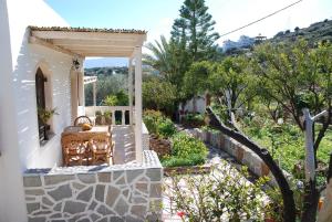 un porche de una casa con un banco y árboles en Villa Italiana en Agios Nikolaos