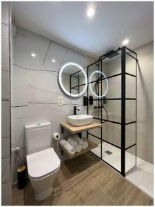 a bathroom with a white toilet and a mirror at Elegance Lifestyle - Parking Gratuito! in San Sebastián