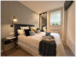 Un dormitorio con una cama grande y una mesa. en Elegance Lifestyle - Parking Gratuito! en San Sebastián