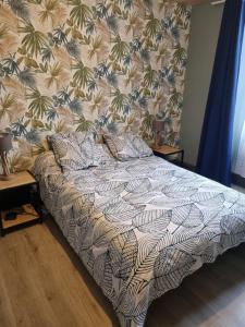 um quarto com uma cama com papel de parede floral em Maison la vague em Meyrueis