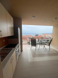 eine Küche mit Blick auf einen Balkon mit einem Tisch in der Unterkunft Villa Ivana in Makarska