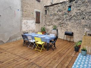 una mesa y sillas en una terraza de madera en Maison la vague, en Meyrueis